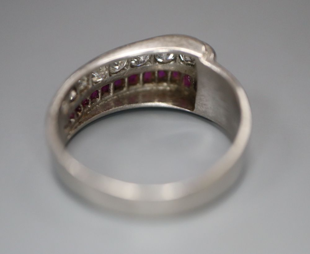 A stylish white metal (stamped Plat), graduated ruby and diamond set twin row dress ring, size O, gross 7.2 grams.